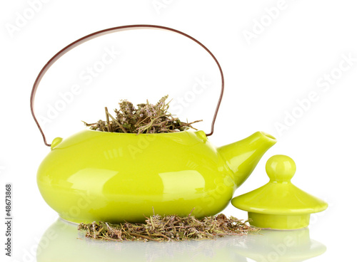 Photo: Dried herbs in teapot, isolated Dried herbs in teapot, isolated