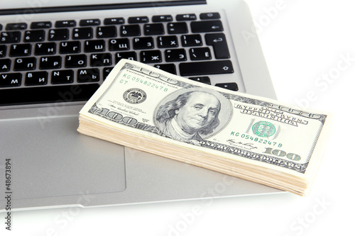 Photo: Money on laptop isolated on white Money on laptop isolated on white