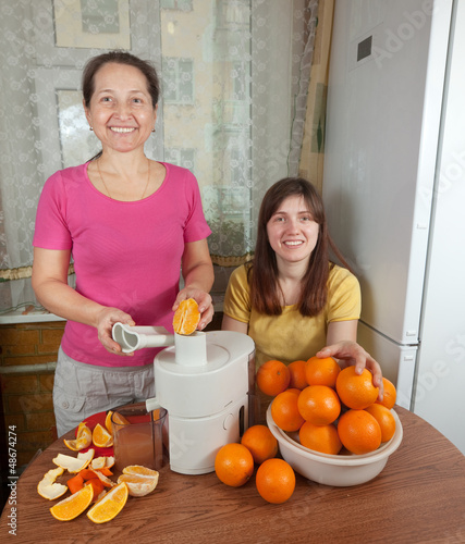 Photo: Two women making fresh orange juice Two women making fresh orange juice