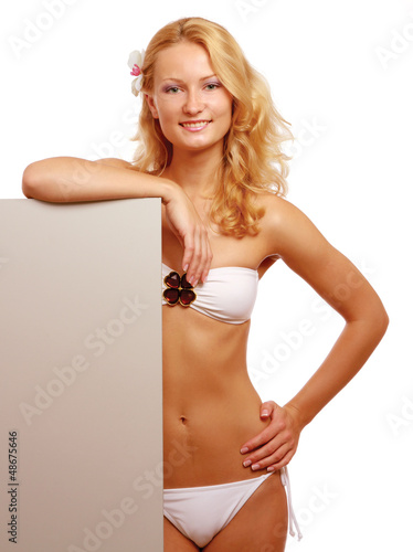 Photo: A young woman in a swimsuit with a blank A young woman in a swimsuit with a blank
