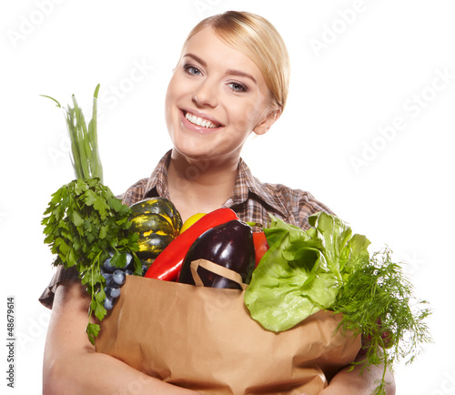 Photo: woman holding a shopping bag full of groceries, mango, salad, r woman holding a shopping bag full of groceries, mango, salad, r