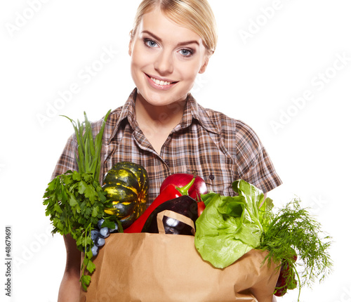 Photo: woman holding a shopping bag full of groceries, mango, salad, r woman holding a shopping bag full of groceries, mango, salad, r
