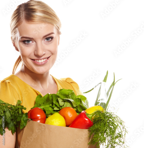 Photo: woman holding a shopping bag full of groceries, mango, salad, r woman holding a shopping bag full of groceries, mango, salad, r