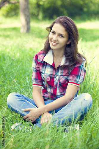 Photo: Beautiful teen girl in the park at green grass. Beautiful teen girl in the park at green grass.