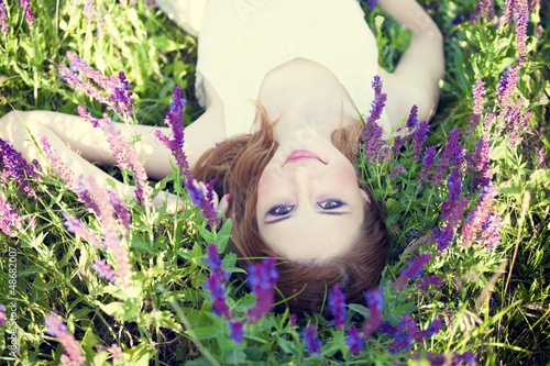Photo: Girl liyng on spring grass and flowers. Girl liyng on spring grass and flowers.