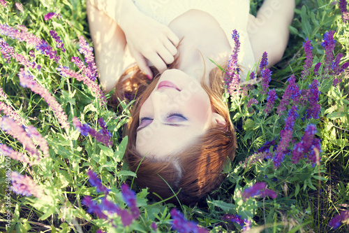 Photo: Girl liyng on spring grass and flowers. Girl liyng on spring grass and flowers.