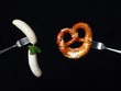 Weisswürste und Breze auf Gabel aufgespießt