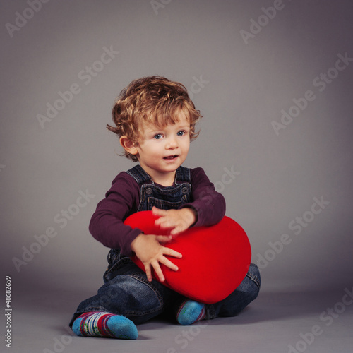 Photo: Little kid with red heart. Studio shot. Little kid with red heart. Studio shot.