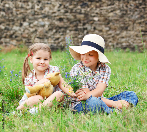 Photo: Little boy gives flowers to the little girl Little boy gives flowers to the little girl