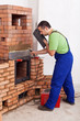Worker installing door to a masonry heater