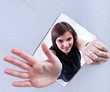 Foto: Young girl waving through a hole in cardboard surface Young girl waving through a hole in cardboard surface