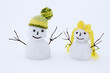 Small snowman couple outdoors in winter.