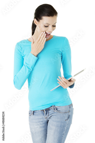 Photo: Young pretty woman working on tablet computer Young pretty woman working on tablet computer