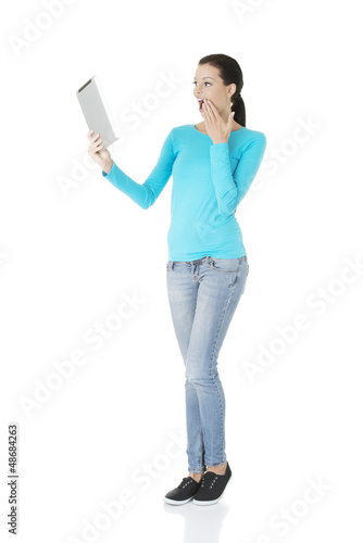 Photo: Young pretty woman working on tablet computer Young pretty woman working on tablet computer