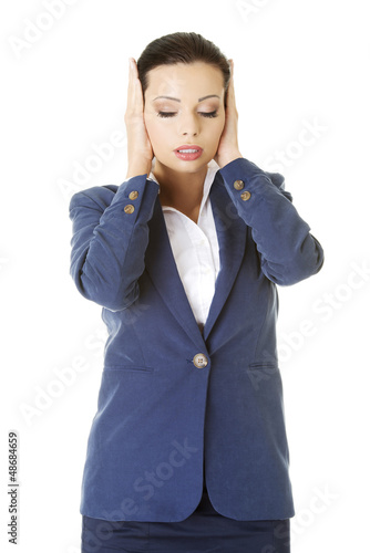 Photo: Attractive businesswoman covering her ears Attractive businesswoman covering her ears