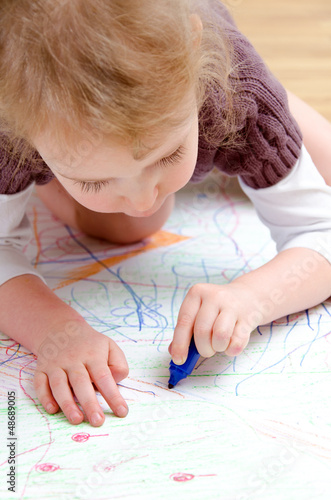 Photo: Cute little girl drawing with pencil Cute little girl drawing with pencil