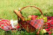 Photo: Picnic basket with red napkin fool of fruits, bread and wine Picnic basket with red napkin fool of fruits, bread and wine
