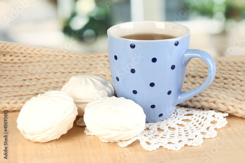 Photo: cup of tea with scarf on table in room cup of tea with scarf on table in room