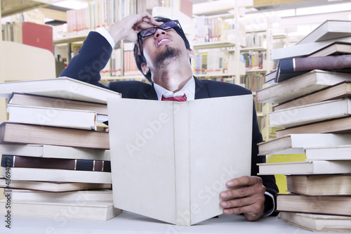 Photo: Stress businessman and stack of books Stress businessman and stack of books