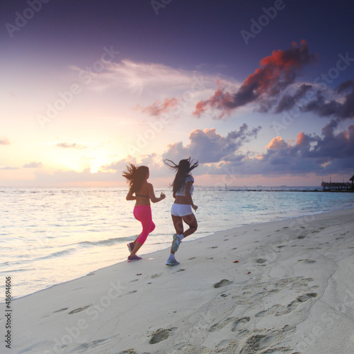 Photo: Two women running on beach Two women running on beach