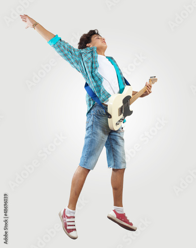 Photo: young man playing on electro guitar and jumping young man playing on electro guitar and jumping
