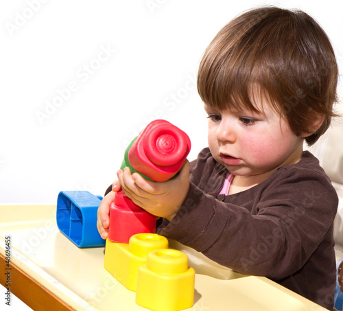 Photo: little girl playing with colorful blocks little girl playing with colorful blocks
