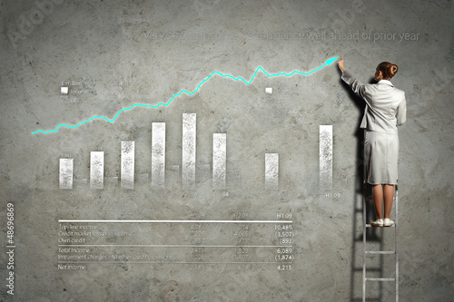 Photo: businesswoman drawing diagrams on wall businesswoman drawing diagrams on wall