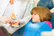 Dentist with toothbrush, denture, and little patient