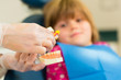 Dentist with toothbrush, denture, and little patient