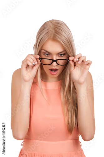 Photo: Surprised blond woman looking down over glasses Surprised blond woman looking down over glasses