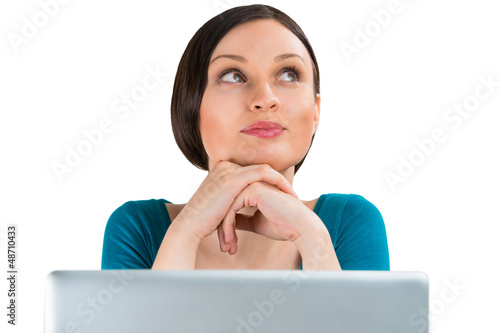Photo: Young pretty woman sitting in front of laptop and thinking about Young pretty woman sitting in front of laptop and thinking about