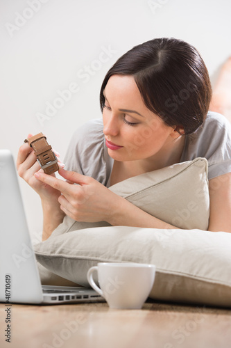 Photo: A young woman lying on the floor in front of her laptop and chat A young woman lying on the floor in front of her laptop and chat