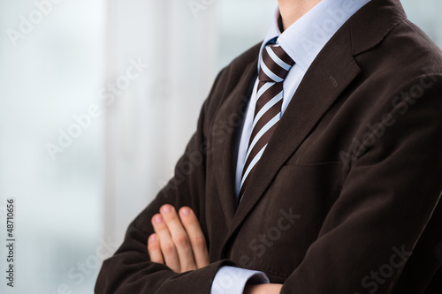 Photo: Closeup of torso of confident business man wearing elegant suit Closeup of torso of confident business man wearing elegant suit