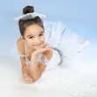 Little ballerina in white dress over blue