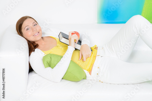 Photo: junge frau entspannt auf dem sofa mit einem buch junge frau entspannt auf dem sofa mit einem buch