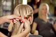 Hairdresser make French braid   in beauty salon.