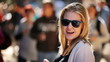 Pretty young woman wearing shades blowing a kiss at the camera w
