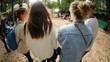 Rearview of four friends walking and talking at an outdoor event