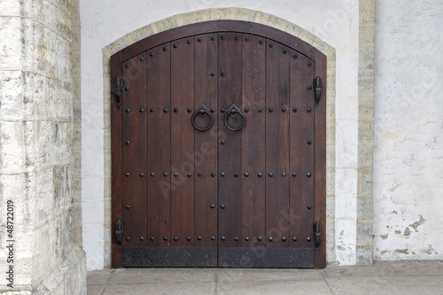 Photo: Dark wooden door with antique metal handles Dark wooden door with antique metal handles