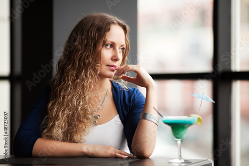 Photo: Sad young woman looking out the window Sad young woman looking out the window