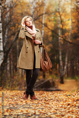 Photo: Young woman walking in autumn forest Young woman walking in autumn forest