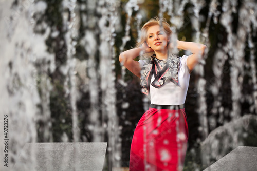 Photo: Happy young woman against a city fountain Happy young woman against a city fountain