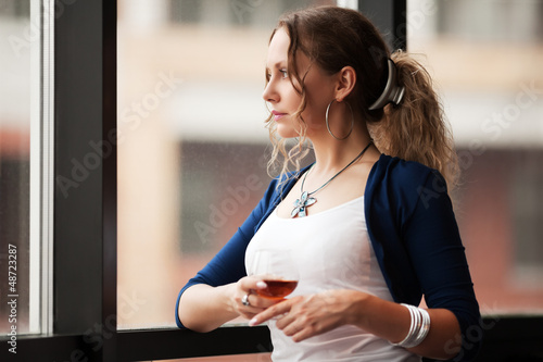 Photo: Beautiful young woman looking out the window Beautiful young woman looking out the window