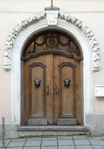 Photo: Old brown wooden door with metal panther heads ornaments Old brown wooden door with metal panther heads ornaments