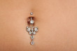 Closeup of a belly button (naval) that is pierced with jewelry