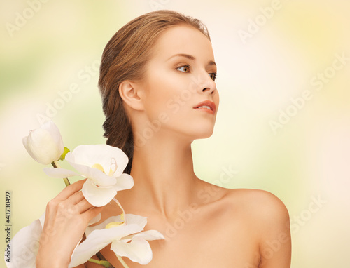 Photo: lovely woman with orchid flower lovely woman with orchid flower