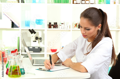 Photo: Young female scientist in laboratory. Young female scientist in laboratory.