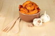 Appetizing village potatoes in bowl on wooden table close-up