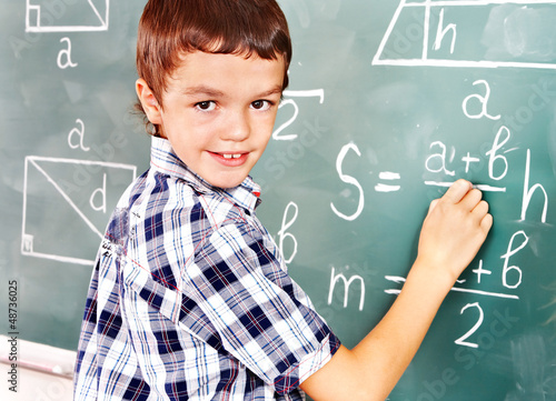 Photo: School child writting on blackboard. School child writting on blackboard.
