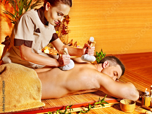 Photo: Man getting herbal ball massage treatments . Man getting herbal ball massage treatments .